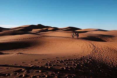 Scenic view of desert against clear blue sky