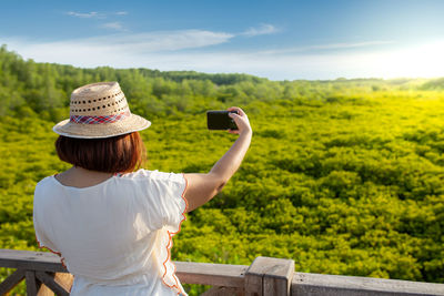 Rear view of woman photographing