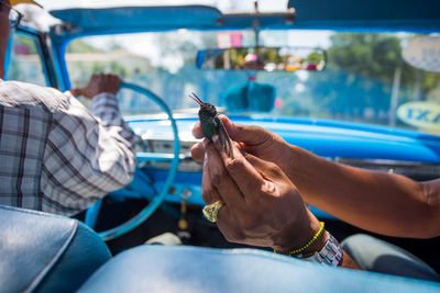 Woman holding toy bird in car with her husband 