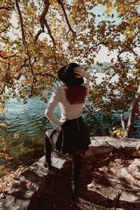 Woman standing on rock against trees