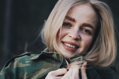 Close-up portrait of young woman wearing camouflage clothing