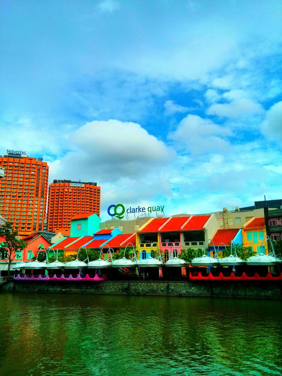 built structure, architecture, water, sky, building exterior, waterfront, cloud - sky, cloud, nautical vessel, transportation, river, cloudy, outdoors, day, blue, multi colored, no people, incidental people, boat, house