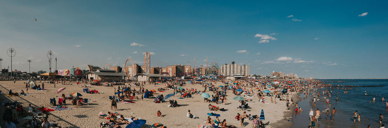 People at beach against sky