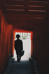Rear view of man standing in corridor of building
