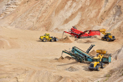 Wheel front-end loader loads sand into a dump truck. heavy machinery in the mining quarry,