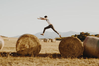 Hay bales on field against clear sky