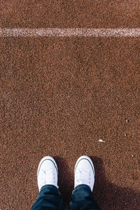 Low section of man standing on tennis ground