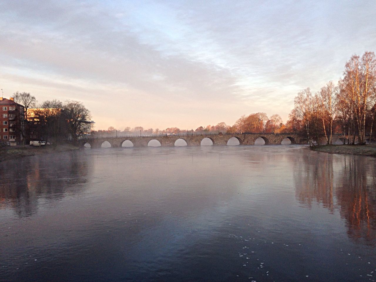 water, waterfront, built structure, reflection, architecture, sky, tree, river, connection, bridge - man made structure, tranquility, lake, nature, tranquil scene, cloud - sky, rippled, beauty in nature, sunset, scenics, outdoors