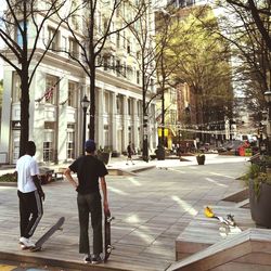 Rear view of people walking on street in city