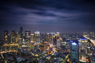 Illuminated cityscape against sky at night