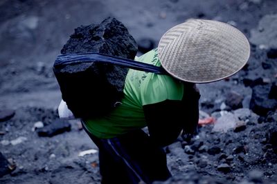 High angle view of person carrying coal on his back