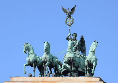 Low angle view of statue against clear blue sky