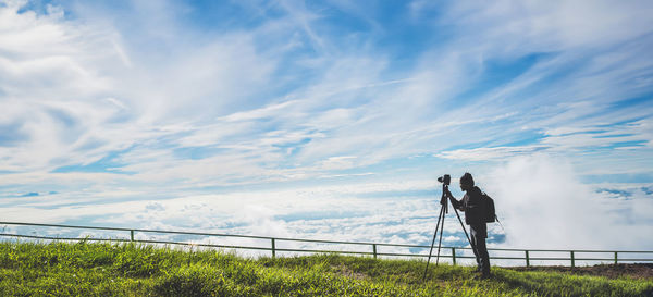 Low angle view of people walking on field against sky