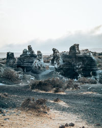 Rock formations on field against clear sky