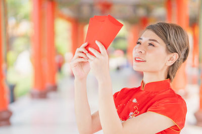 Portrait of woman holding red umbrella