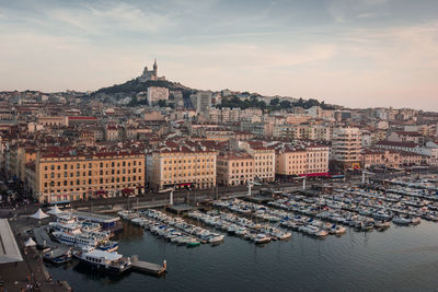 Aerial view of cityscape by sea against sky