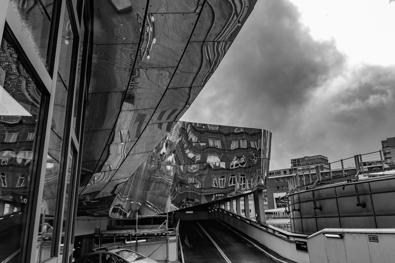 LOW ANGLE VIEW OF BRIDGE AMIDST BUILDINGS IN CITY