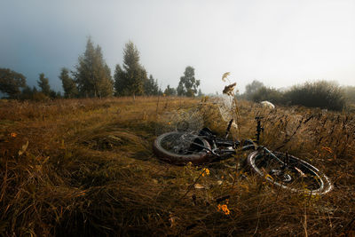 Bicycle parked on field against sky