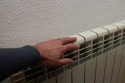 Midsection of man playing guitar against wall