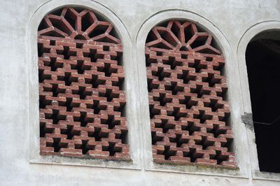 Close-up of brick wall by window on building
