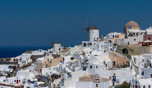 Buildings in city against clear blue sky