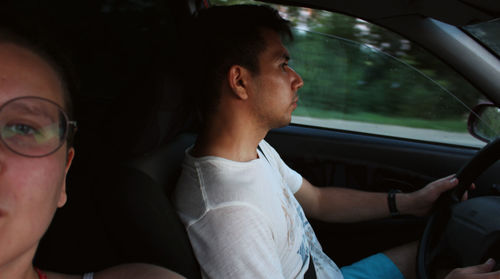 Portrait of woman sitting in car with man