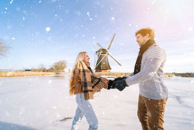 Full length of woman standing on snow covered field