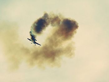 Low angle view of airplane flying against sky