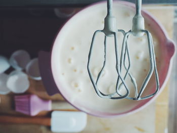 Directly above shot of electric mixer over batter in bowl on table