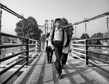 Rear view of woman standing on footbridge