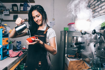 Young woman working on barbecue grill