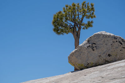 Low angle view of rocks against clear blue sky