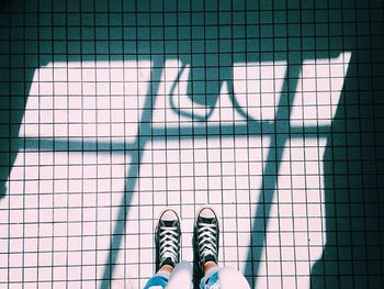 Low section of people standing on tiled floor