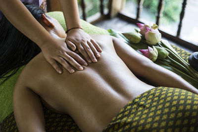 Midsection of woman getting herbal message at spa