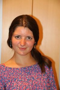 Close-up portrait of a young woman against wall