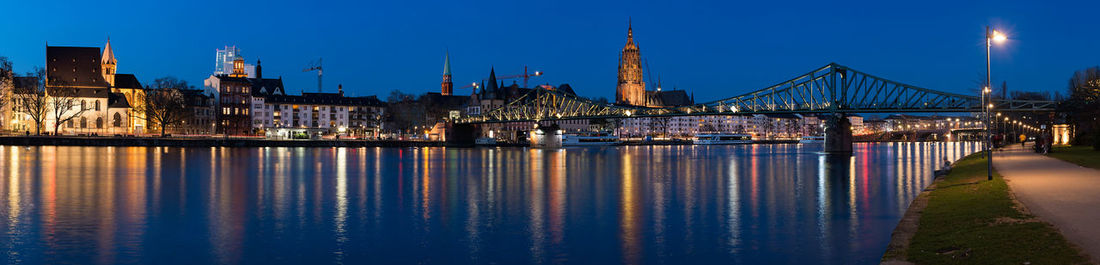 Panoramic view of eiserner steg over main river with frankfurt cathedral against sky