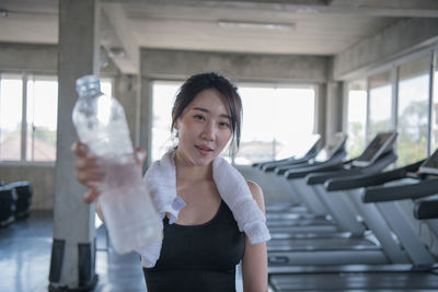 Portrait of woman standing against glass