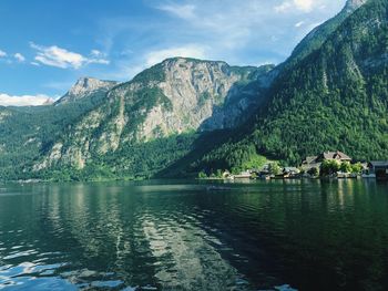 Scenic view of lake by mountains against sky