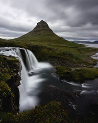 Scenic view of waterfall against sky