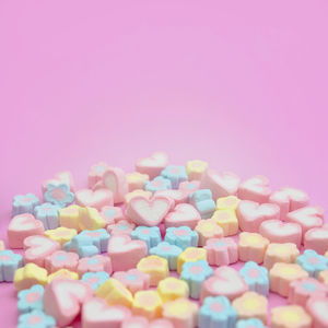 Close-up of multi colored candies against pink background