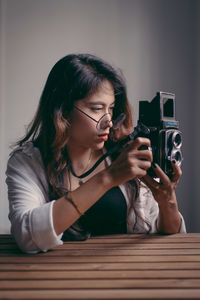 Portrait of young woman looking through camera