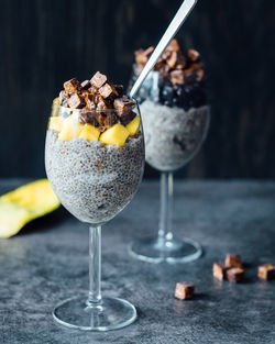Close-up of chia pudding with chocolates and mango slices on table