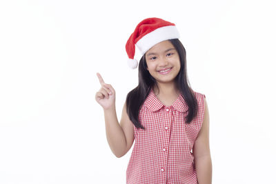 Portrait of smiling girl standing against white background