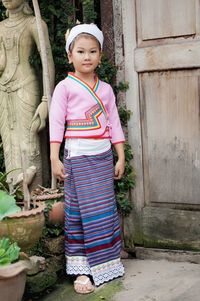 Portrait of girl standing against wall