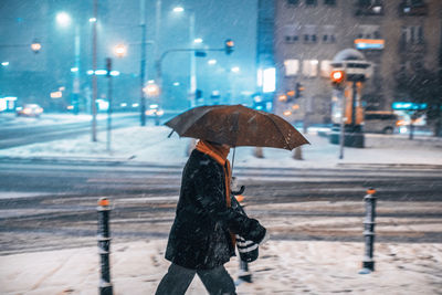 Woman walking on wet road in rainy season