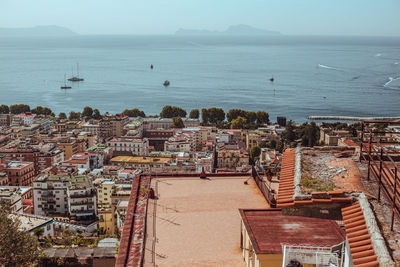 High angle view of townscape by sea against sky