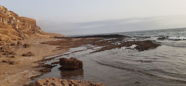 Scenic view of rocks in sea against sky