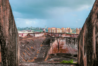 View of old buildings against cloudy sky