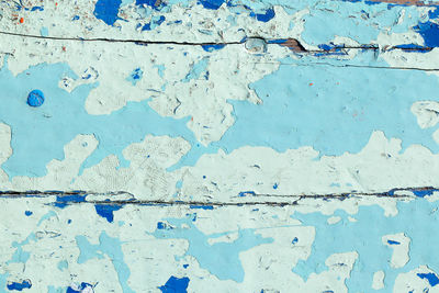 Close up shot of old light blue paint texture peeling off wood plank background