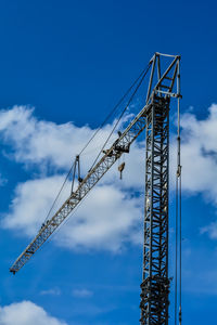 Low angle view of crane against blue sky